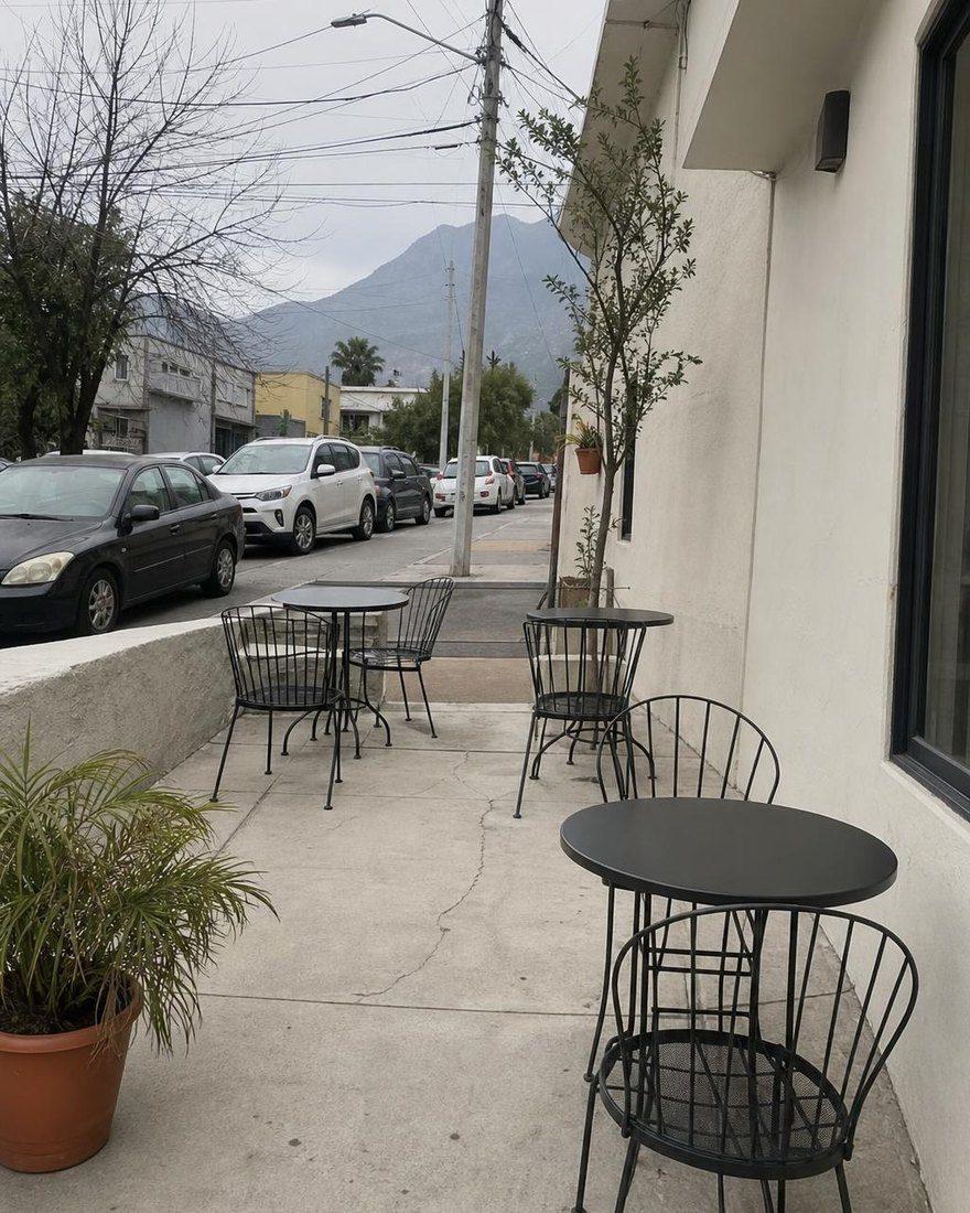 Handyfoto der leeren Terrasse bei Tag mit Straße und Berg im Hintergrund