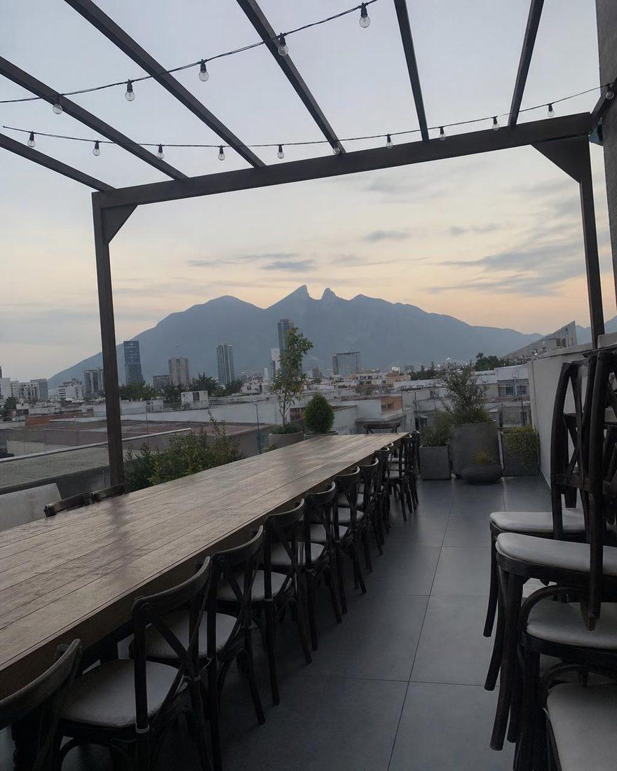 Handyfoto einer langen Tafel auf der Terrasse bei Tag mit dem Berg im Hintergrund